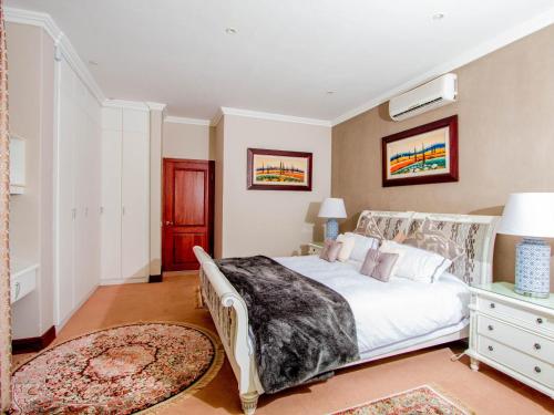 a bedroom with a large white bed and a rug at Bophirima Boutique Hotel in Rustenburg