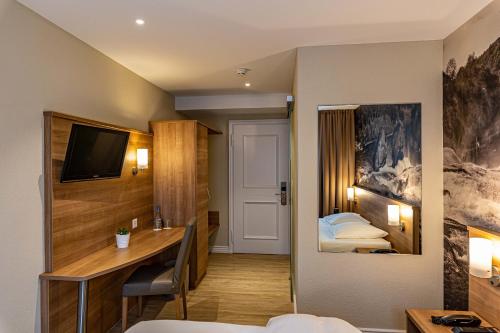 a hotel room with a desk and a bed at Hotel Kronenhof in Schaffhausen