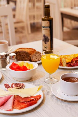 una tavola ricoperta di piatti di cibo e un bicchiere di succo d'arancia di Playacanela a Isla Canela