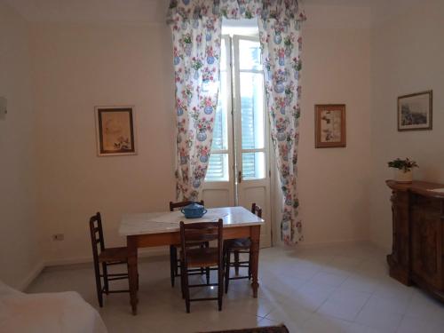una sala da pranzo con tavolo, sedie e finestra di Casa jacaranda a Cagliari