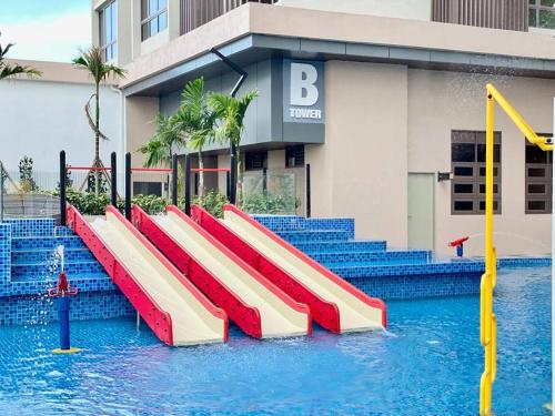 een rij glijbanen in het water voor een gebouw bij Bali Residence I Luxury 2BR I 6-10pax I Jonker St I Water Park I City Centre by Jay Stay in Melaka