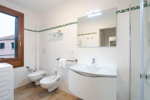 a white bathroom with a sink and a toilet at Rimon Residence in Venice