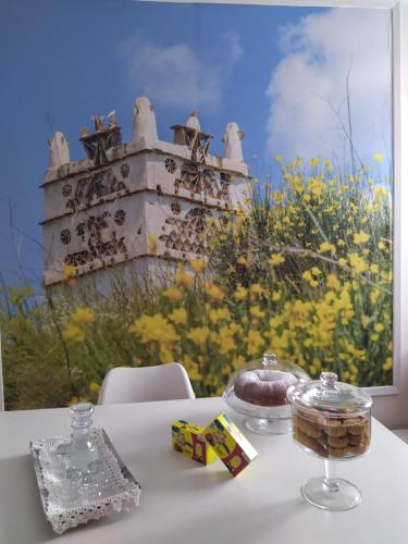 a table with a cake and a painting of a castle at DelMar Tinos in Tinos Town
