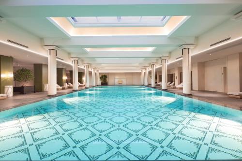 a swimming pool with a blue tile floor in a building at Suning Zhongshan Golf Resort in Nanjing