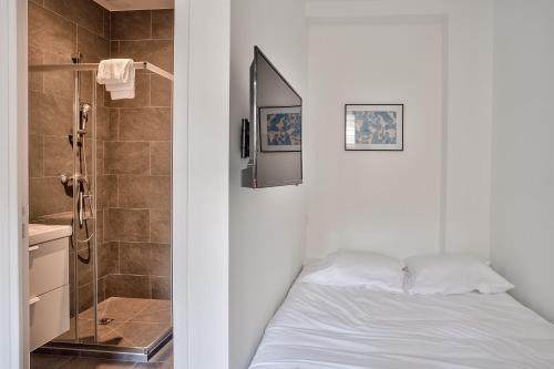 a bedroom with a white bed and a shower at Cosy Residence Paris Sud in Ivry-sur-Seine