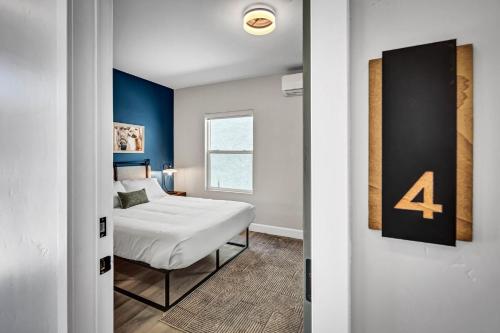 a bedroom with a bed and a blue accent wall at Single Bedroom - Queen Size. Heart of Downtown Vista in Vista