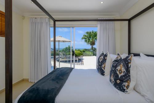 a bedroom with a bed and a view of the ocean at 11 on Fairway Beach Villa in Southbroom