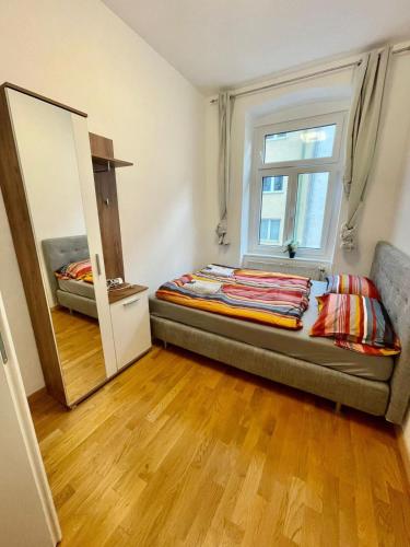 a small bedroom with a bed and a mirror at Deluxe Studio 3P TH in Vienna