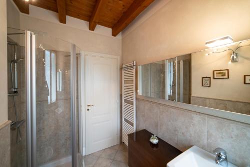 La salle de bains est pourvue d'une douche, d'un lavabo et d'un miroir. dans l'établissement ROMANTIC LAKE VIEW HOUSE, à Sulzano