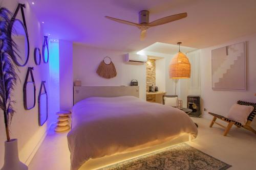 a bedroom with a large bed with purple lighting at LES BAINS D’EROS in Cuers