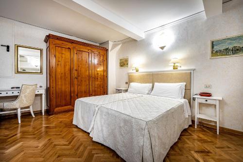 a bedroom with a bed and a table and a chair at Hotel Alessandra in Florence