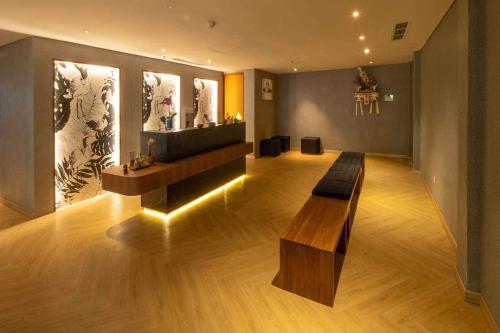 a room with a bench in the middle of a room at Swarga Suites Bali Berawa, Marclan Collection in Canggu