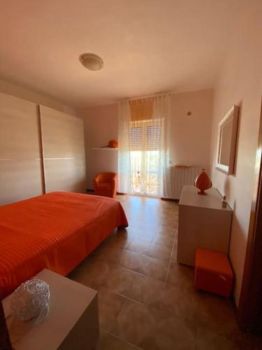 ein Schlafzimmer mit einem roten Bett und ein Wohnzimmer in der Unterkunft Casa Linda in Cisternino