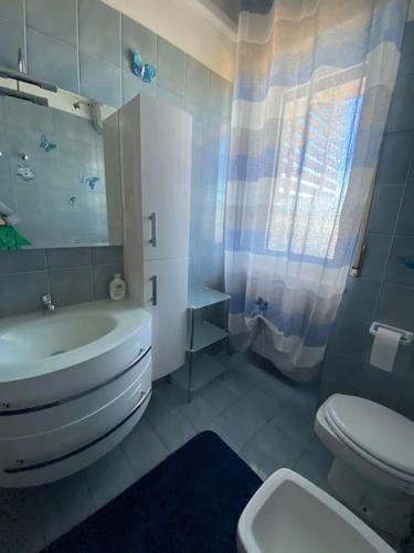 ein weißes Bad mit einem WC und einem Waschbecken in der Unterkunft Casa Linda in Cisternino