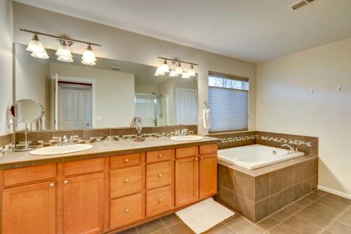 a bathroom with two sinks and a tub and a large mirror at Spacious Kent Home Near SeaTac Airport with Patio in Kent