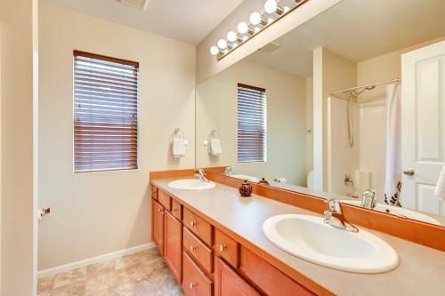 a bathroom with two sinks and a large mirror at Spacious Kent Home Near SeaTac Airport with Patio in Kent