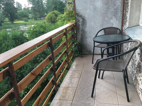 un patio con 2 sillas y una mesa en el balcón en Fejas Dzīvoklis, en Vecpiebalga