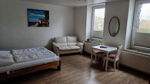 ein Wohnzimmer mit einem Bett, einem Tisch und einem Stuhl in der Unterkunft Jutta vom Kutter in Wulfen auf Fehmarn