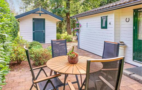a wooden table and chairs on a patio with a shed at Stunning Home In Vorden With Wifi in Vorden