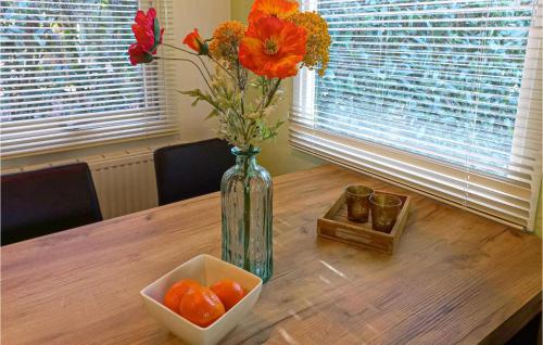 a vase with flowers and a bowl of oranges on a table at Stunning Home In Vorden With Wifi in Vorden