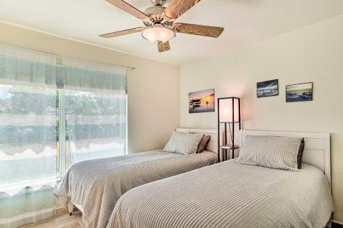 two beds in a bedroom with a ceiling fan at Cape Coral Vacation Rental with Private Pool! in Cape Coral