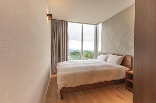 a bedroom with a bed and a large window at 水晶- Suishou in Niseko