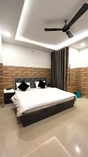 a bedroom with a bed with a ceiling fan at Hotel Shanti Residency in Katra