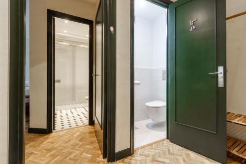 a bathroom with a green door and a toilet at ZUBIETA by SWEET HOME SAN SEBASTIAN in San Sebastián