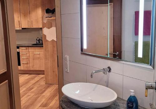ein Bad mit einem Waschbecken und einem Spiegel in der Unterkunft Ferien- und Freizeithof Bindl in Sankt Englmar