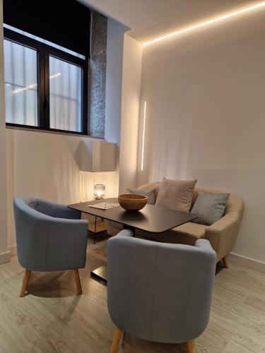 salon z kanapą, stołem i krzesłami w obiekcie Apartamentos WUR w Madrycie