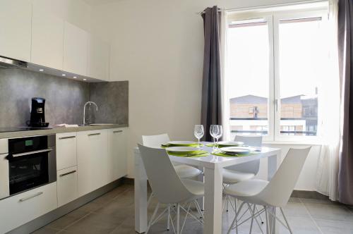 - une cuisine avec une table blanche et des chaises blanches dans l'établissement Cheverus - Appartement 1 chambre avec ascenseur et Parking, à Bordeaux
