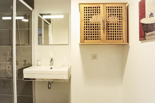 une salle de bain avec un lavabo et une douche en verre dans l'établissement Cheverus - Appartement 1 chambre avec ascenseur et Parking, à Bordeaux