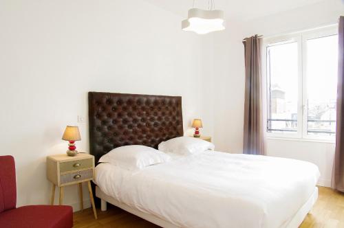una camera con un grande letto e una finestra di Cheverus - Appartement 1 chambre avec ascenseur et Parking a Bordeaux