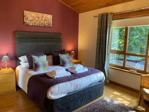 a bedroom with a bed with towels on it at Silver Birch Lodge with Hot Tub in Cupar