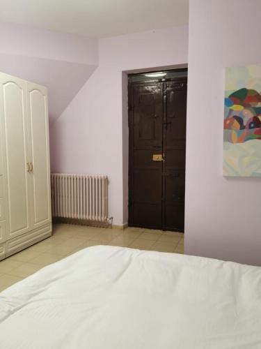 a bedroom with a white bed and a black door at Reina's Room in Bethlehem