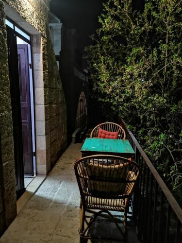 a table and chairs on a balcony with a table and a door at Reina's Room in Bethlehem