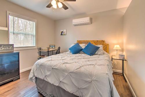 een slaapkamer met een bed met blauwe kussens en een televisie bij Peaceful Missouri Cabin Rental on 55 Acres! in Canton