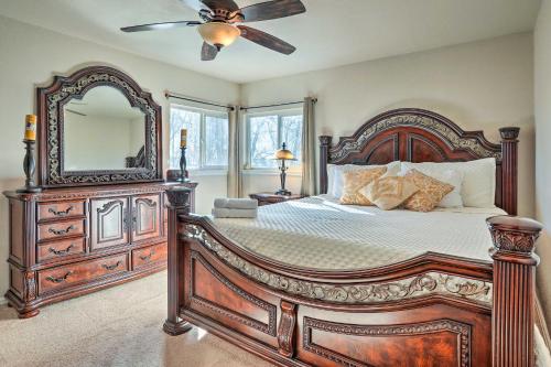 a bedroom with a large wooden bed and a mirror at Colorado Springs House 5 Mi to Downtown in Colorado Springs