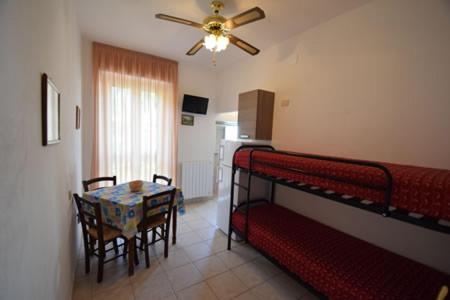 Cette chambre comprend une table, un lit et une salle à manger. dans l'établissement Hotel Villa Miramare, à Capoliveri