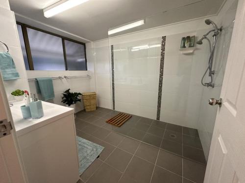 a bathroom with a shower and a sink at Our Beach House in Bribie Island in Bongaree