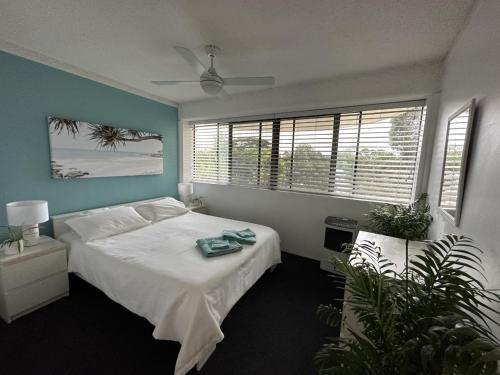 a bedroom with a bed and a large window at Our Beach House in Bribie Island in Bongaree