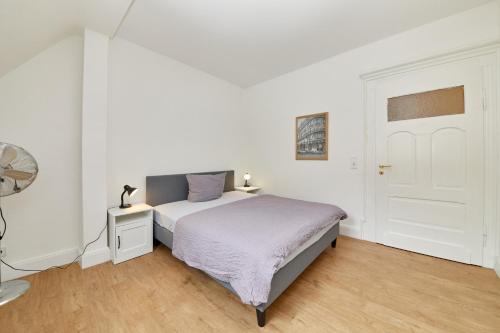 een witte slaapkamer met een bed en een witte deur bij Fewo am Gestade 1 in Bernkastel-Kues