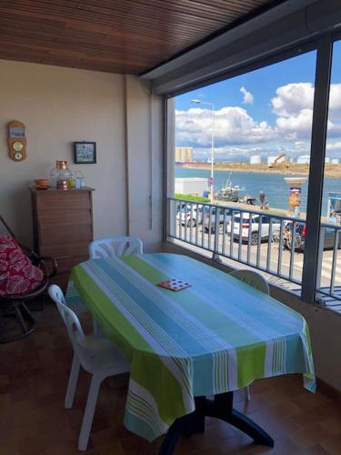 - une salle à manger avec une table et une vue sur l'eau dans l'établissement Appart T2 vue imprenable sur le canal et la mer, à Port-la-Nouvelle