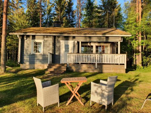 una pequeña casa con una mesa y sillas frente a ella en Lomamokkila Cottages, en Savonlinna
