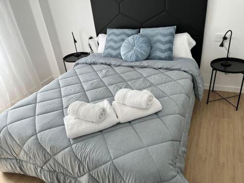 a bedroom with a large bed with towels on it at Centro Plaza Sardoy in Murcia