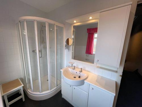 baño blanco con ducha y lavamanos en Pass the Keys Beautiful Period Property in Central Location en Maxwelltown