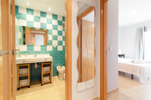 ein Badezimmer mit Waschbecken und Toilette in einem Zimmer in der Unterkunft Global Properties, Apartamento con terraza y piscina en la playa de Canet in Canet d'en Berenguer