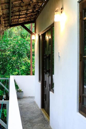a hallway leading to a house with a door at Light Moon Villa in Ahangama