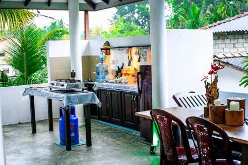 an outdoor kitchen with a table and a stove at Light Moon Villa in Ahangama