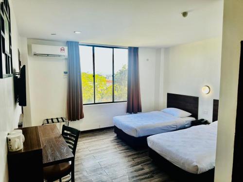 a hotel room with two beds and a table at Langkawi Baron Hotel - renovated 2023 in Kuah